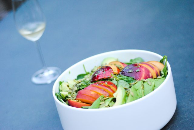 peach avocado salad with homemade dressing and a glass of white wine