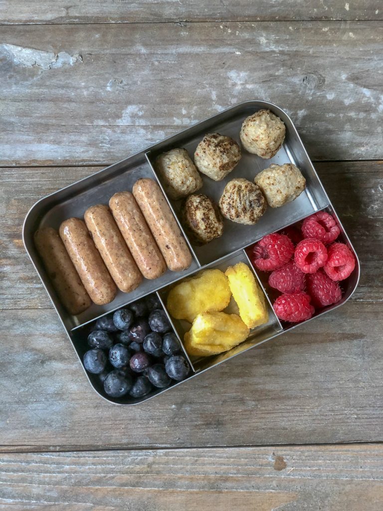 variety of sausage, chicken nuggets, and meatballs with blueberries and raspberries