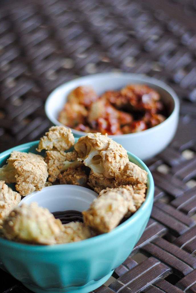 breaded cauliflower sitting in a bowl - one with bbq sauce on it, and one without