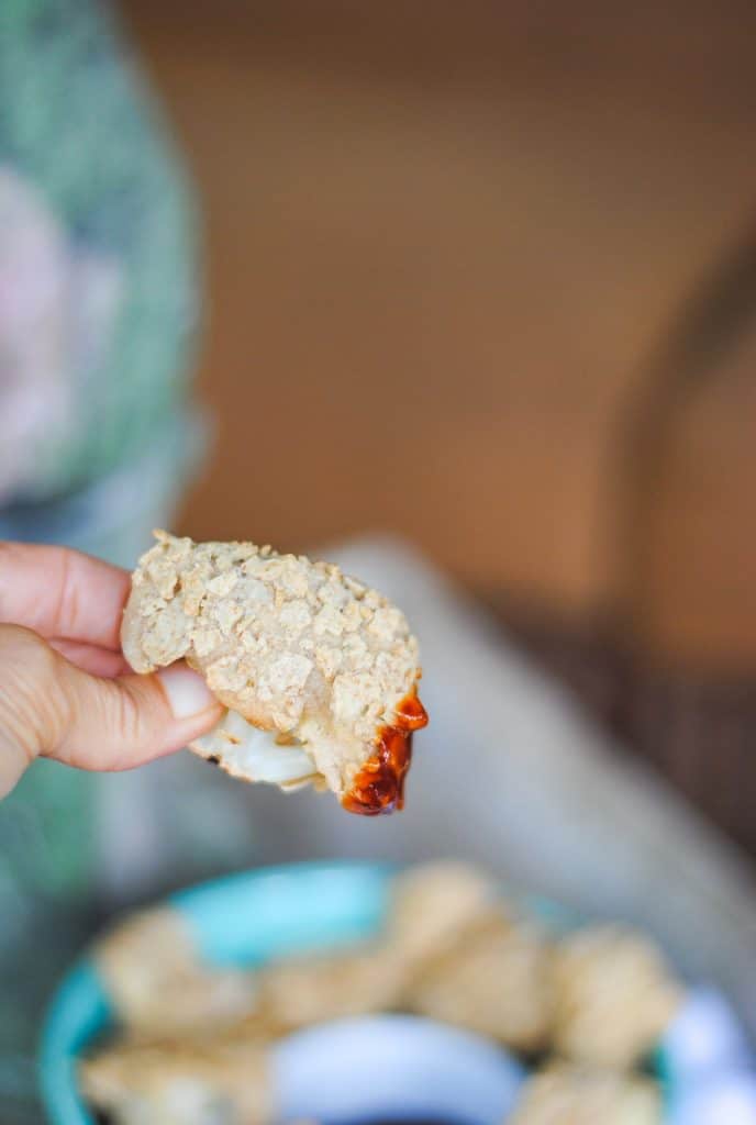 a piece of the vegan breaded cauliflower dipped in BBQ sauce