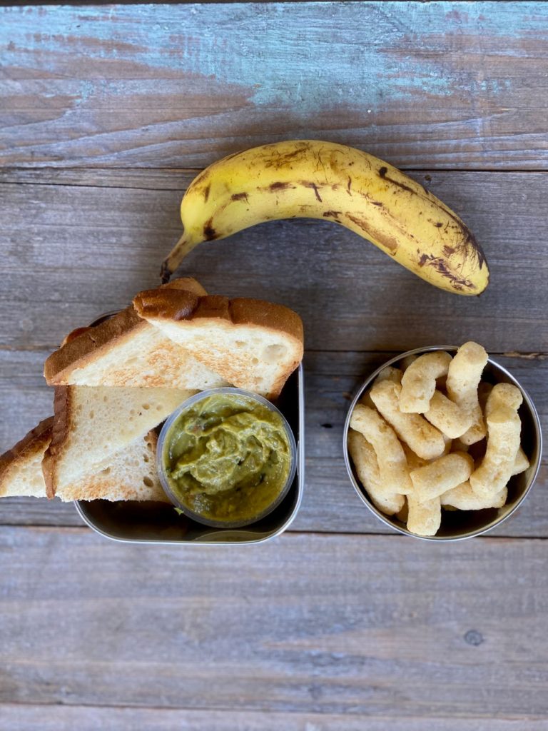 Toasted bread, guacamole, banana, Hippeas lunch for kids