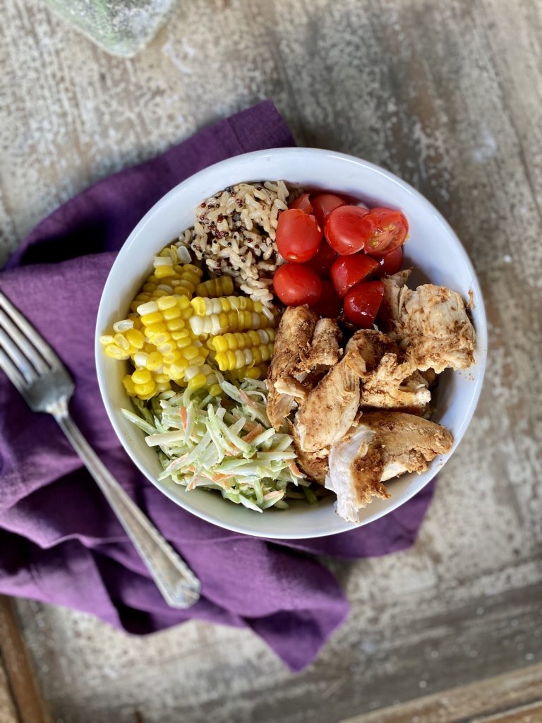 rice and quinoa bowl with smoky chicken, coleslaw, corn and tomatoes