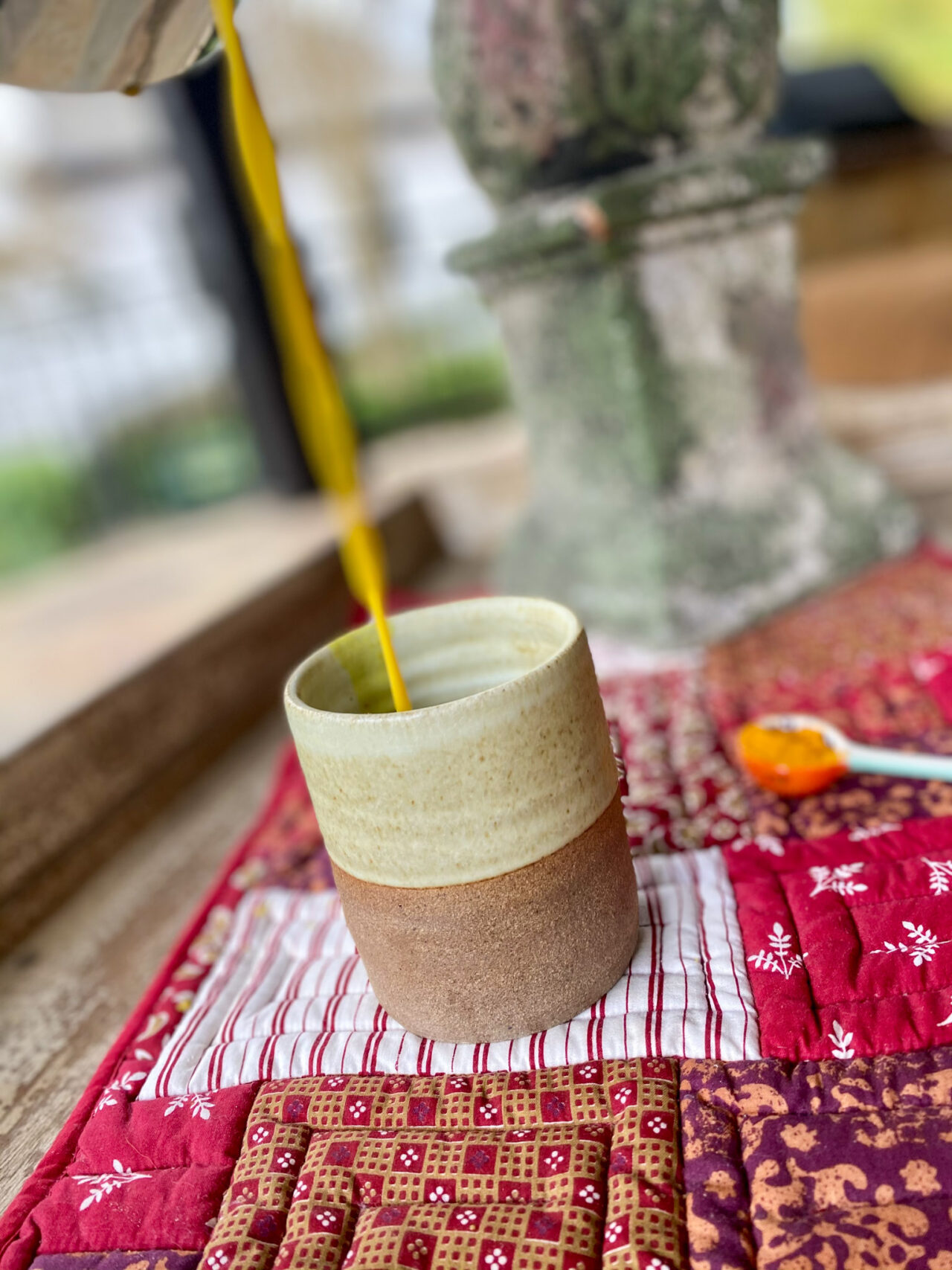 pouring turmeric tea into a cup