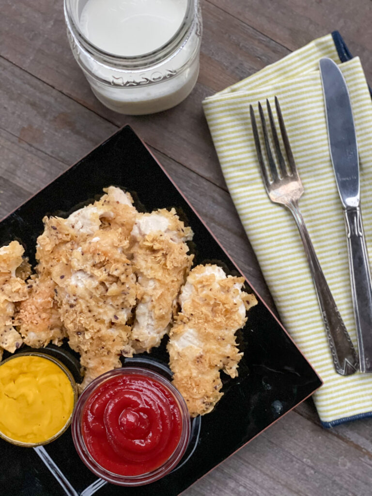 baked chicken tenders on a plate with 2 dipping sauces