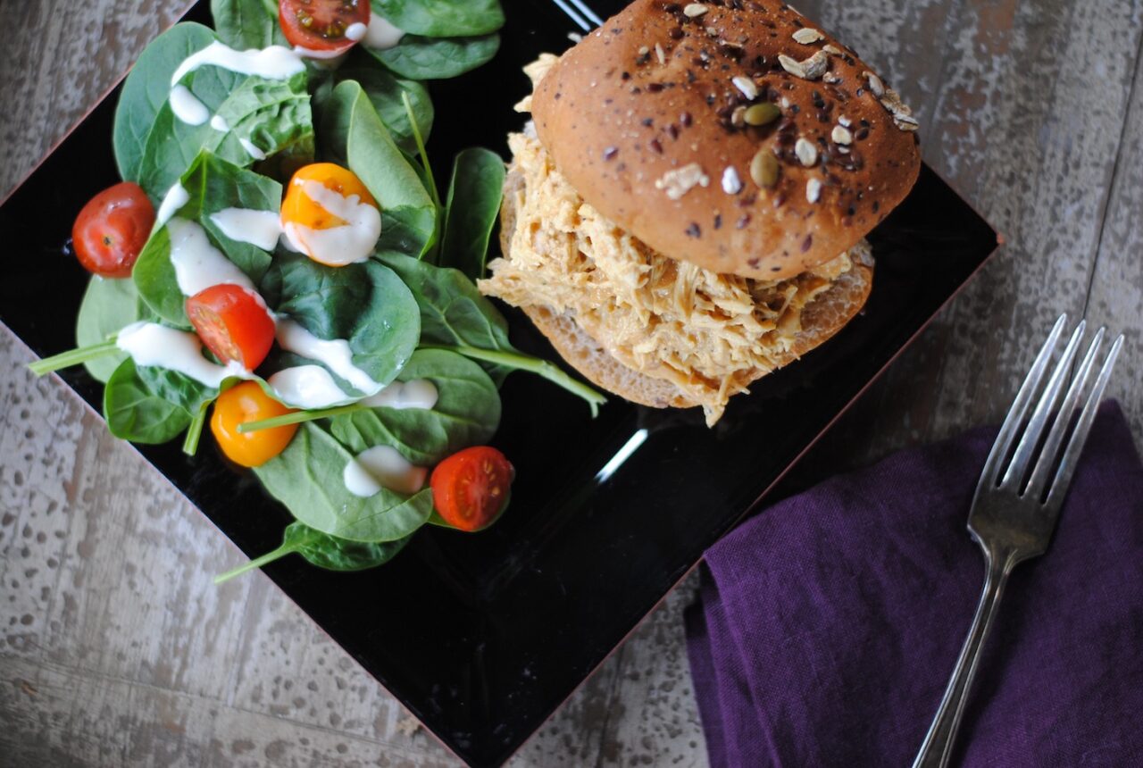 dairy free honey mustard slow cooker chicken on a bun on a plate